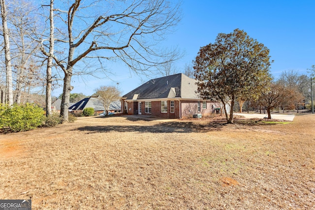 view of side of home with a yard and brick siding