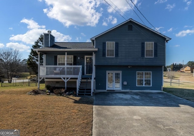 tri-level home featuring a front yard, french doors, fence, and a chimney