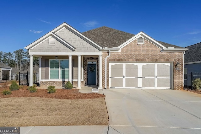 craftsman-style house featuring driveway, a garage, fence, and brick siding