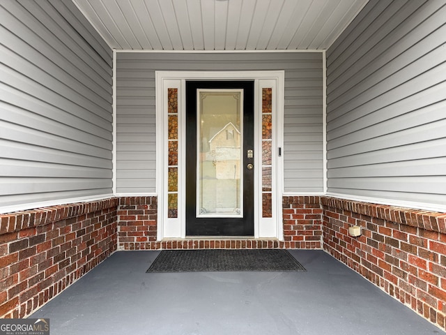 view of exterior entry with brick siding