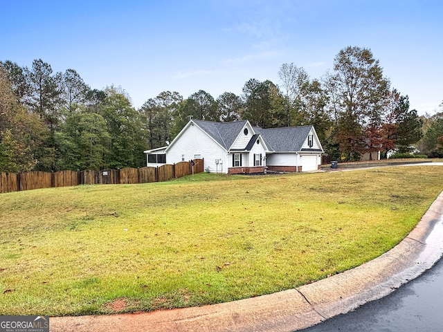 exterior space featuring a garage, fence, and a front lawn