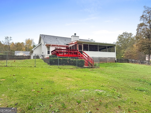 back of property with a sunroom, a fenced backyard, a chimney, and a lawn