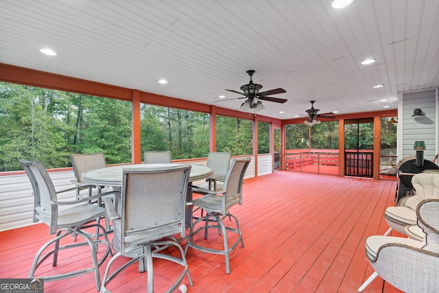 wooden deck with a ceiling fan and outdoor dining area