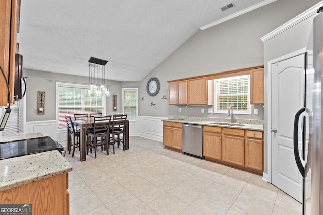 kitchen featuring visible vents, lofted ceiling, a wainscoted wall, stainless steel appliances, and a sink