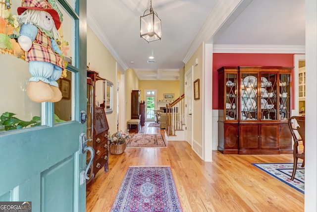 foyer entrance featuring visible vents, stairway, crown molding, and wood finished floors