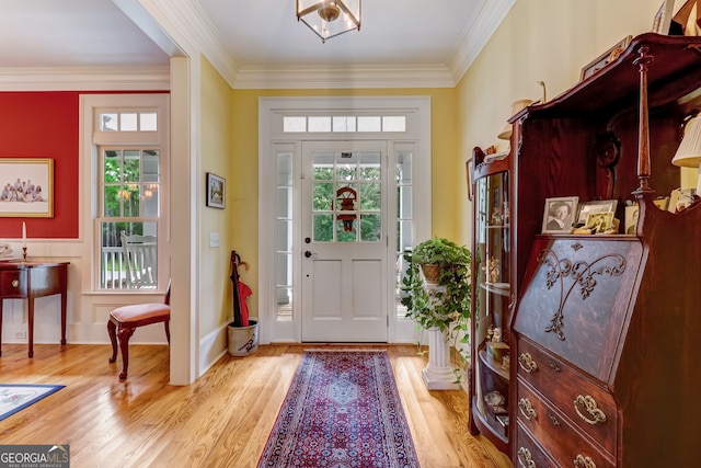 entryway featuring ornamental molding, light wood-type flooring, and baseboards