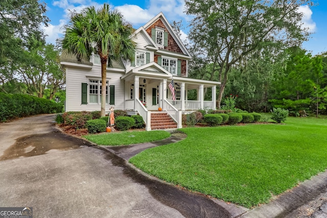 view of front of house with covered porch, driveway, and a front lawn