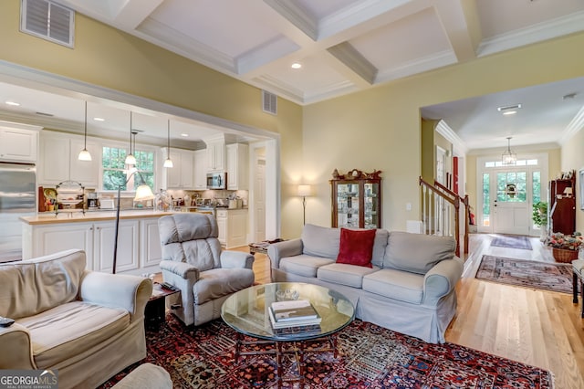 living room featuring beam ceiling, plenty of natural light, coffered ceiling, and visible vents