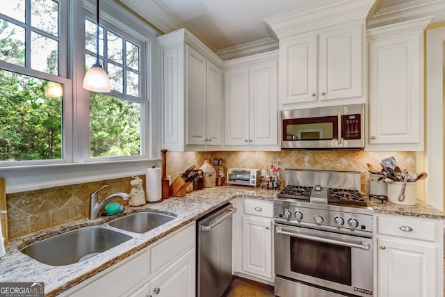 kitchen with appliances with stainless steel finishes, white cabinets, and a sink