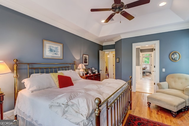 bedroom featuring recessed lighting, a raised ceiling, ornamental molding, ceiling fan, and wood finished floors