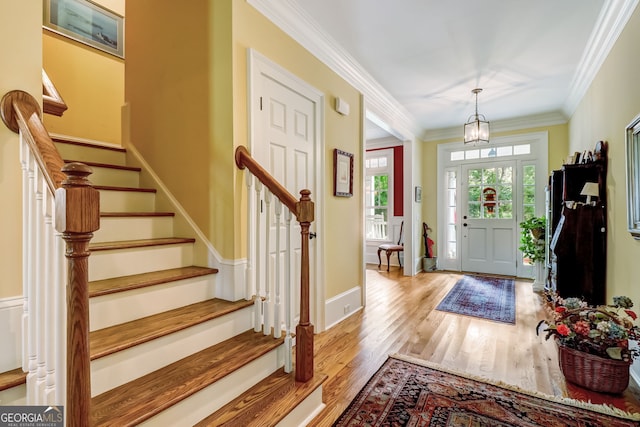 entrance foyer with stairway, crown molding, light wood-style flooring, and baseboards