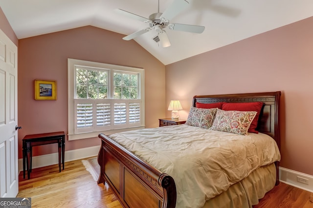 bedroom featuring a ceiling fan, baseboards, vaulted ceiling, and wood finished floors