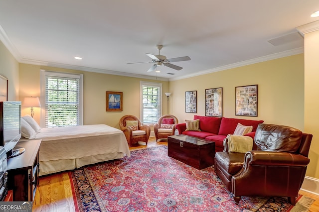 bedroom with ceiling fan, multiple windows, crown molding, and wood finished floors