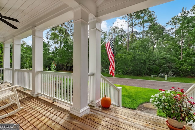 wooden terrace featuring covered porch and a ceiling fan