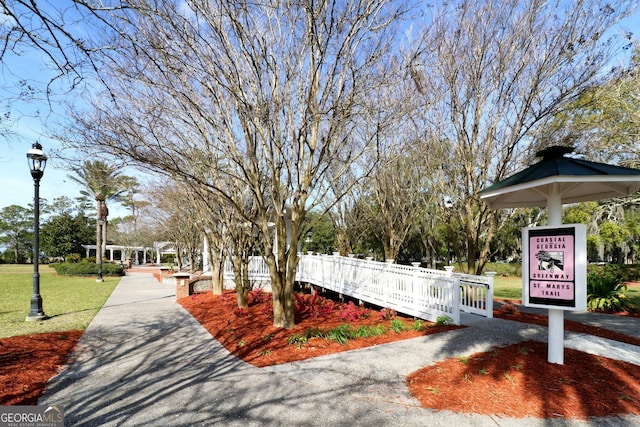 view of home's community featuring fence and a lawn