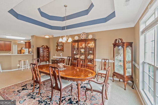 dining space with baseboards, a tray ceiling, carpet flooring, and an inviting chandelier