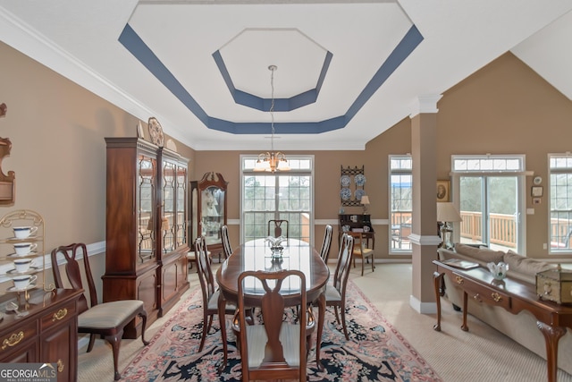 dining space featuring a tray ceiling, a chandelier, crown molding, and light colored carpet