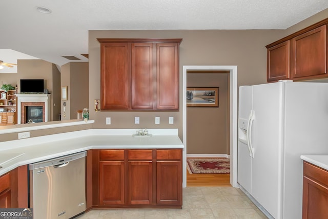 kitchen with light countertops, a ceiling fan, a textured ceiling, white fridge with ice dispenser, and dishwasher