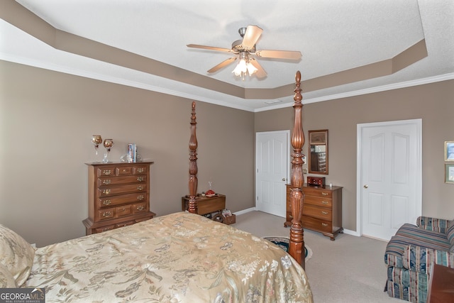 carpeted bedroom featuring ceiling fan, ornamental molding, a raised ceiling, and baseboards