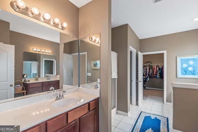 bathroom featuring baseboards, a stall shower, vanity, and tile patterned floors