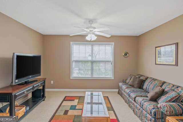 carpeted living area featuring ceiling fan and baseboards