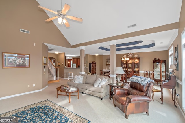 living room featuring ceiling fan, light carpet, visible vents, stairway, and decorative columns