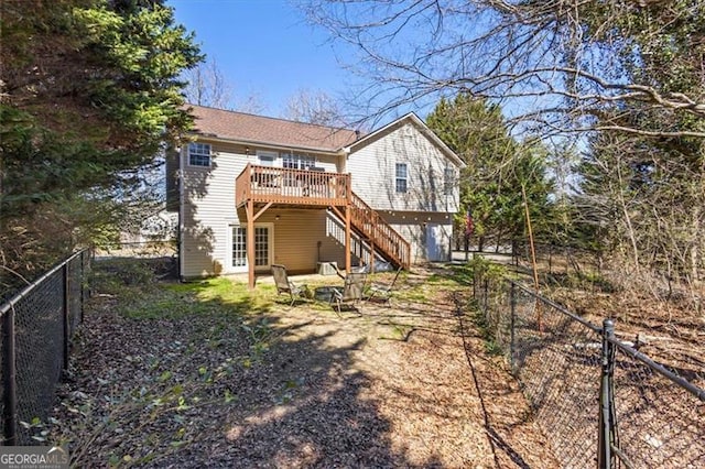 back of property with a fenced backyard, stairway, and a deck