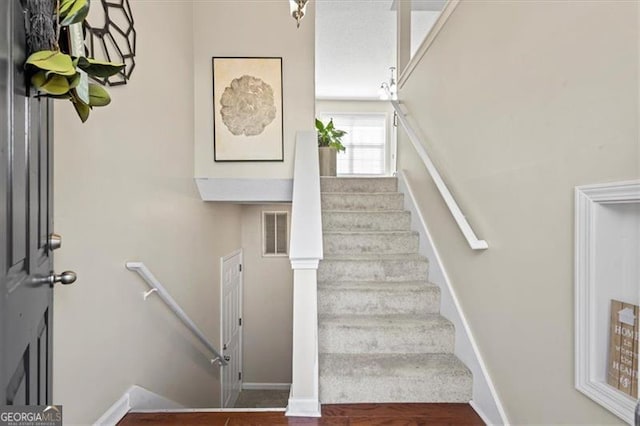 staircase with visible vents and baseboards