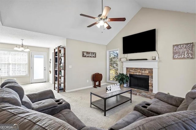 living room featuring baseboards, a fireplace with raised hearth, carpet flooring, high vaulted ceiling, and ceiling fan with notable chandelier