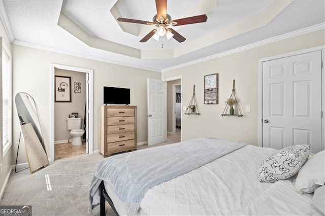 bedroom with light colored carpet, a ceiling fan, baseboards, a raised ceiling, and crown molding