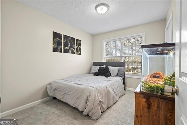 carpeted bedroom featuring a textured ceiling and baseboards