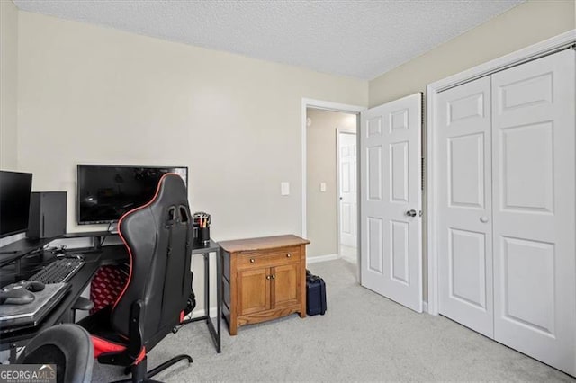 office space featuring a textured ceiling, baseboards, and light colored carpet