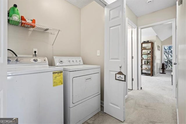 washroom featuring light carpet, laundry area, and washing machine and dryer