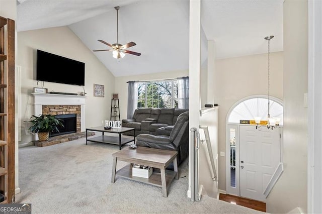 living room featuring high vaulted ceiling, carpet flooring, a fireplace, and ceiling fan with notable chandelier