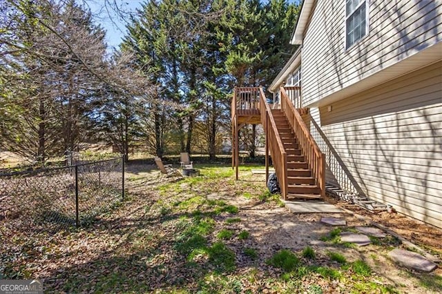 view of yard with fence, stairway, and a wooden deck