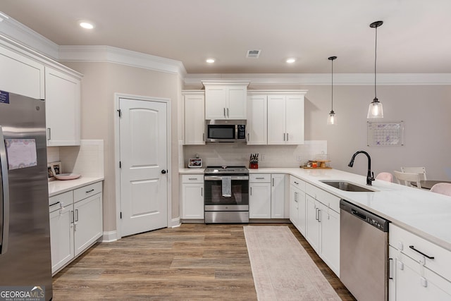 kitchen featuring visible vents, appliances with stainless steel finishes, white cabinetry, a sink, and wood finished floors