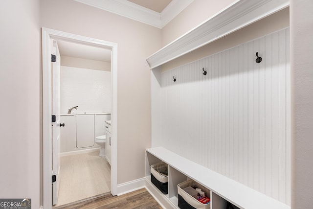 mudroom with baseboards, wood finished floors, and crown molding