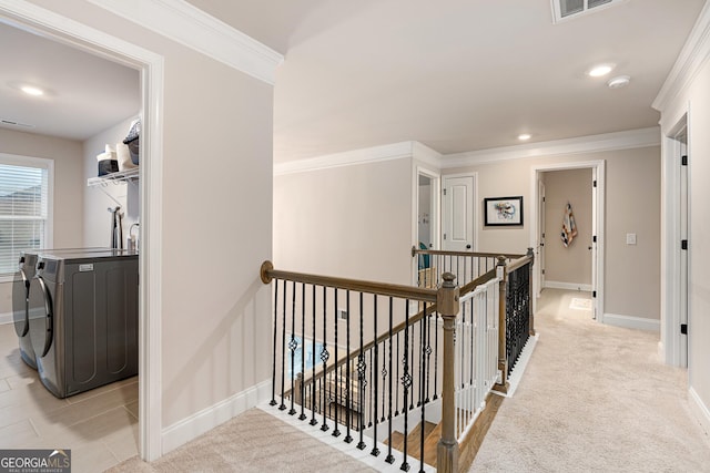 hallway with ornamental molding, light carpet, an upstairs landing, washer and dryer, and baseboards