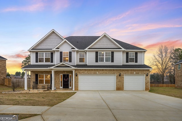 view of front facade featuring a garage, concrete driveway, brick siding, and fence