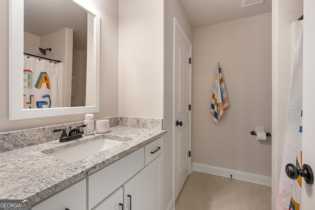 bathroom featuring visible vents, baseboards, and vanity