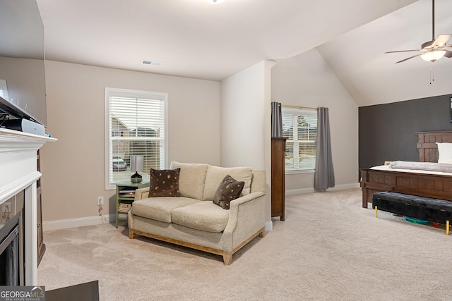 living area with lofted ceiling, light colored carpet, a fireplace, and visible vents