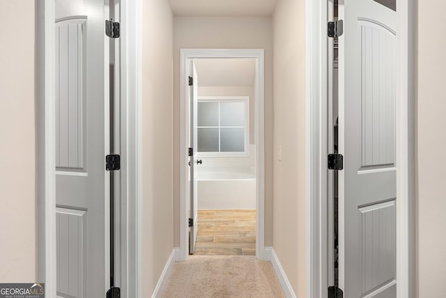 hallway with carpet and baseboards