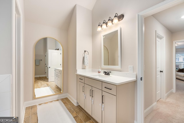 bathroom with vanity, baseboards, and ensuite bathroom