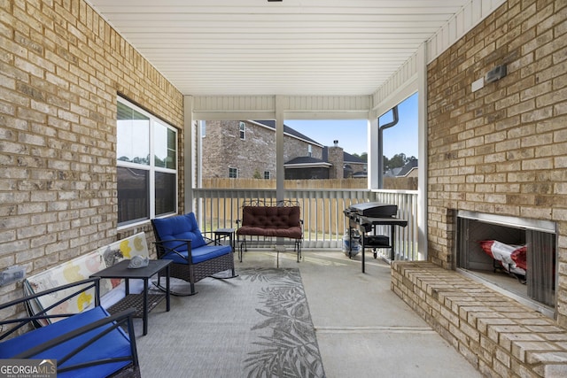 sunroom / solarium featuring an outdoor brick fireplace and a wealth of natural light