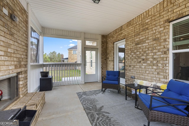 sunroom featuring an outdoor brick fireplace