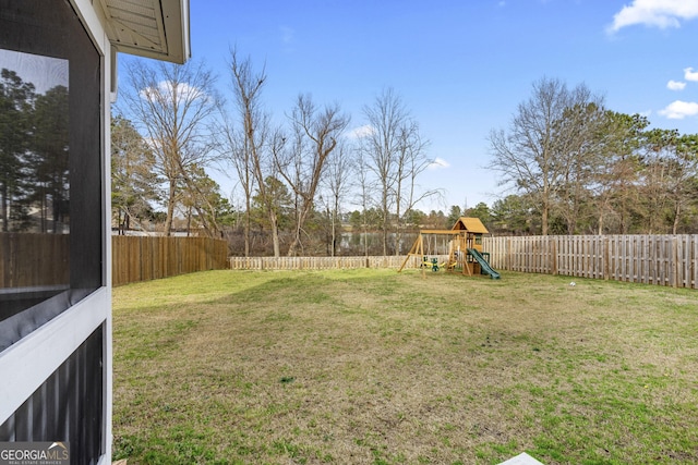 view of yard with a fenced backyard and a playground