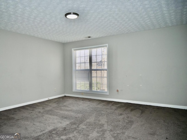 carpeted spare room with baseboards and a textured ceiling