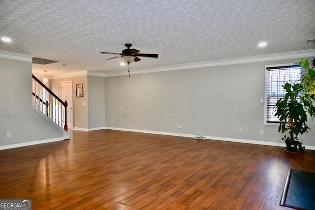 unfurnished living room featuring baseboards, stairway, ornamental molding, wood finished floors, and a textured ceiling