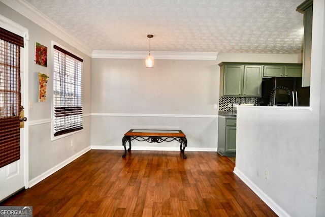 dining room with a textured ceiling, dark wood-type flooring, ornamental molding, and baseboards