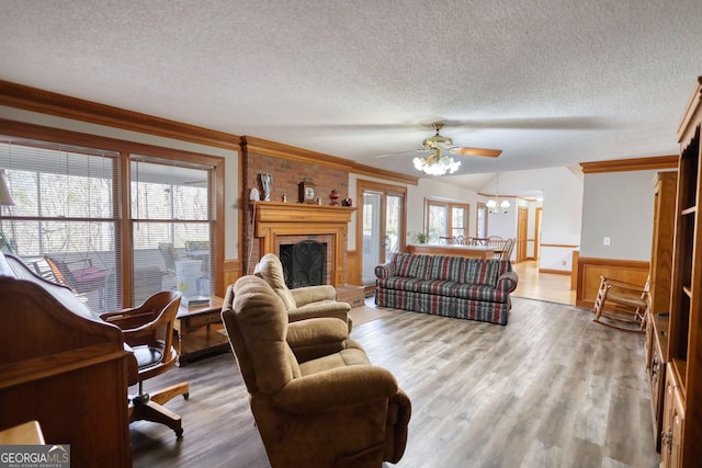 living area featuring wainscoting, crown molding, a textured ceiling, and wood finished floors